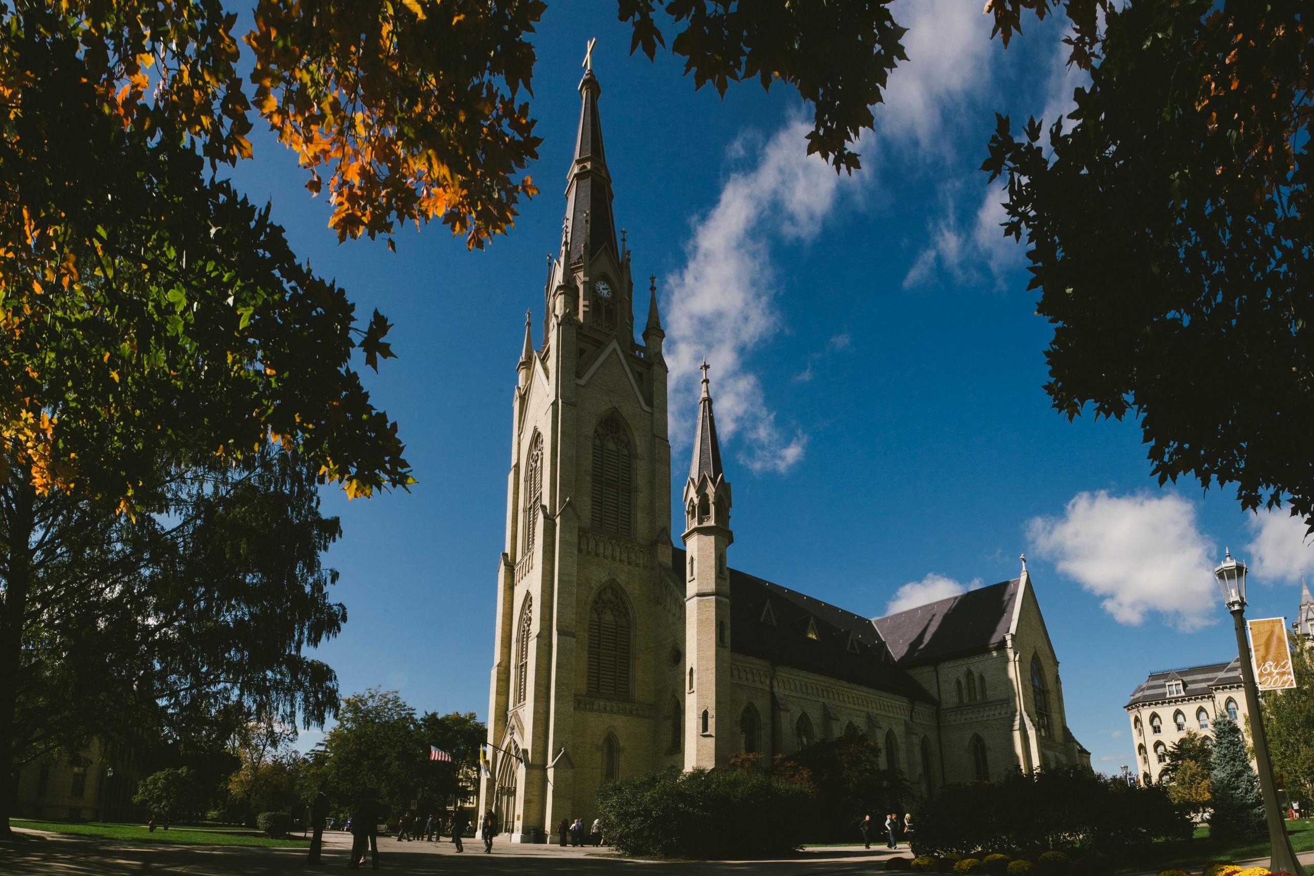 Basilica of the Sacred Heart at Notre Dame University from the side and framed by trees in autumn