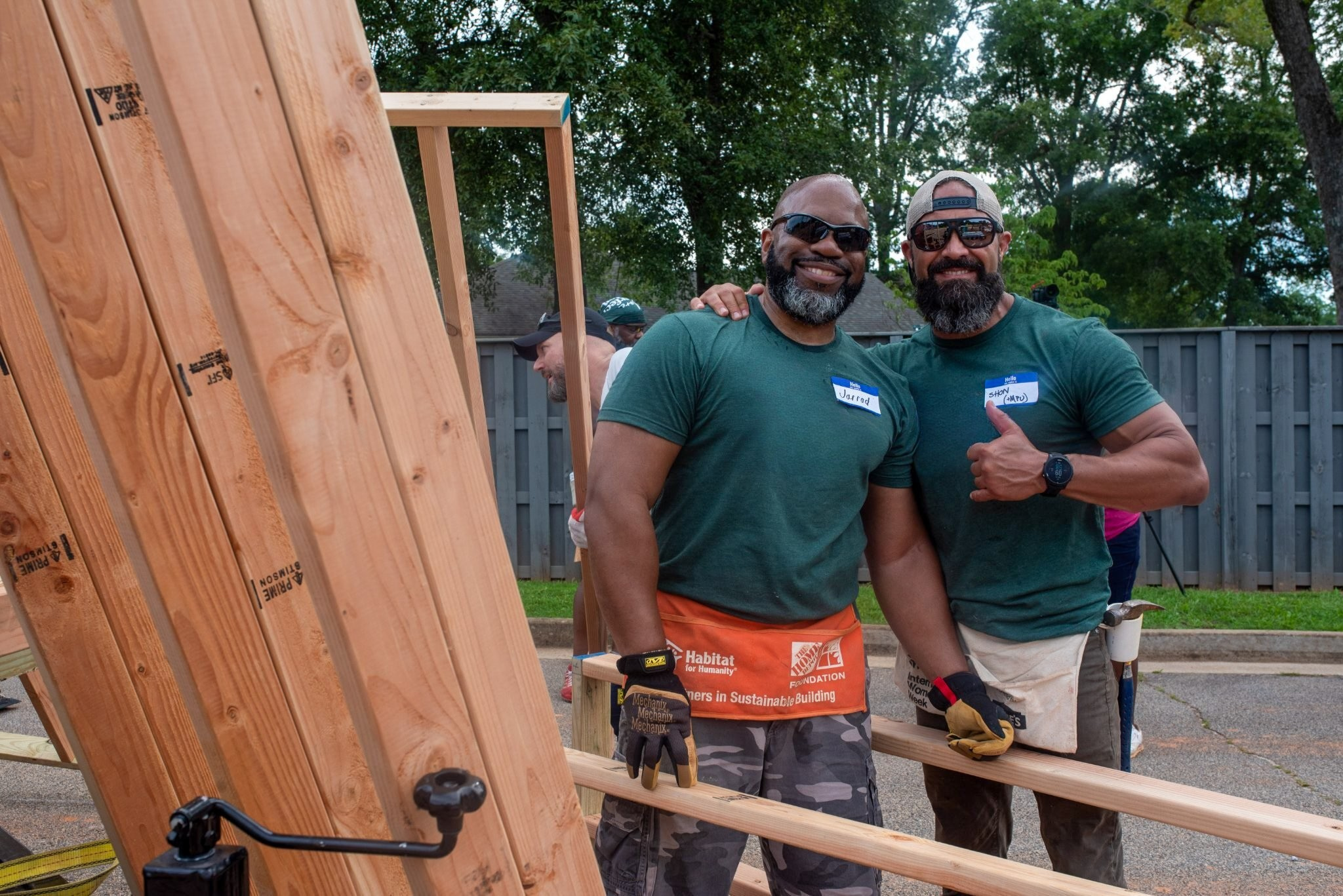 two men smiling at the camera at a habitat for humanity home build with The Brickyard